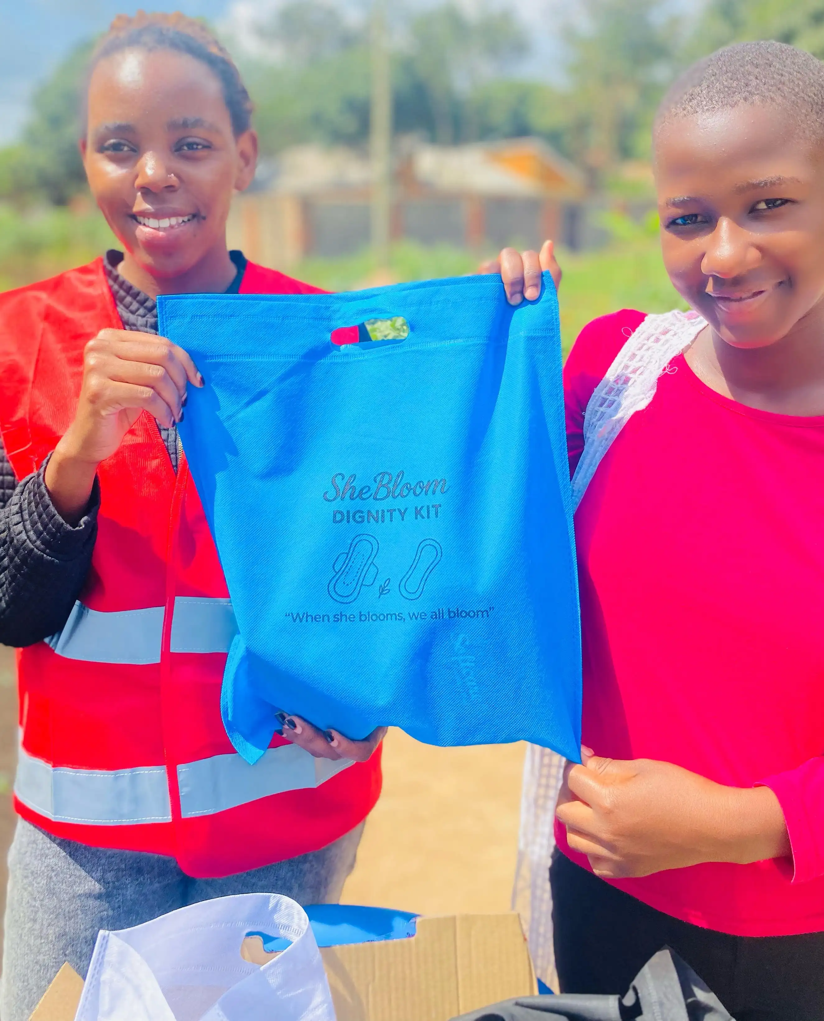 Shebloom volunteer giving a girl a dignity kit